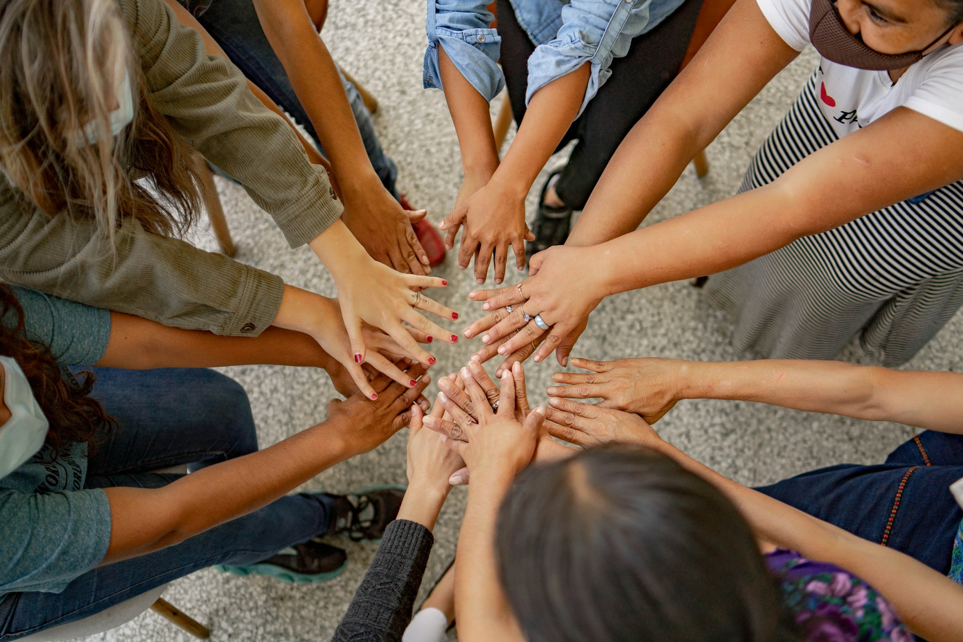 A group of people standing in a circle with their hands together